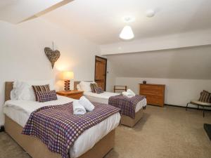 a bedroom with two beds and a dresser in it at Cwm in Betws-y-coed