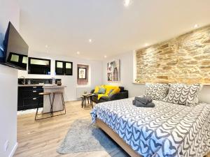 Un dormitorio con una cama y una sala de estar. en LE CALLOCH 1G - Wifi - Parking Facile - Gare, en Quimper