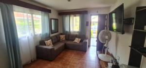 uma sala de estar com um sofá e algumas janelas em Pura Vida Villa! Beachfront Golf and Country Club Los Delfines 24 hours security em Tambor