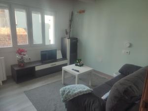 a living room with a couch and a tv and a table at Apartamento TerradeAugas3 in Caldas de Reis