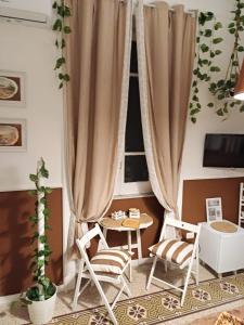 um quarto com cadeiras, uma mesa e uma janela em Giordano's home em Nápoles
