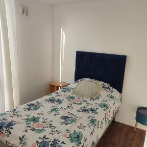 1 dormitorio con 1 cama con cabecero azul en Wiracocha departamento, en Ovalle