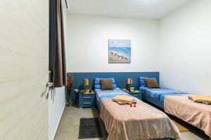 2 letti in una camera con pareti blu di Spacious Brand New Apartment 3 Bdr 2Bth Bugibba HC12 a San Pawl il-Baħar