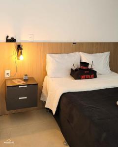 a hotel room with a bed with a night stand at Nosso Apê 915: Piscina | TV Box | Academia - NA2002 in Juiz de Fora