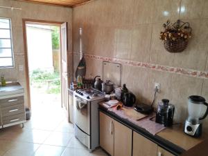 uma cozinha com fogão e um balcão com panelas e frigideiras em Lugarzinho Aconchegante - Q1 em Curitiba