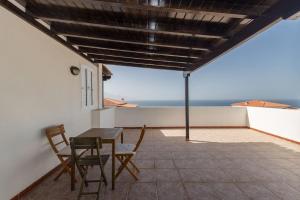 Una mesa y sillas en un balcón con vista al mar. en Ático con terraza en Agaete, en Agaete