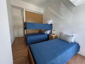a bedroom with a bed with a blue bedspread at Mar y Rio Duplex in Playa Unión
