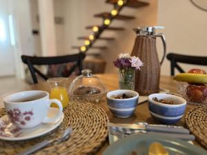 a wooden table with cups and plates of food on it at Mar y Rio Duplex in Playa Unión