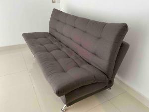un sofá marrón sentado en una habitación en LA CASA BLANCA Suites Tepic SPA Familiar en Tepic