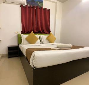 a bedroom with a large bed with a red curtain at Hotel Fortune Heights in Hyderabad