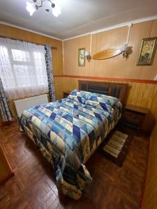 a bedroom with a bed with a colorful comforter at Hostal Josmar Natales in Puerto Natales