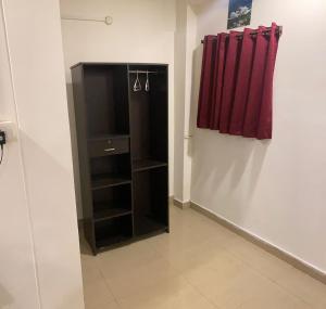 a black cabinet in a room with a red curtain at Hotel Fortune Heights in Hyderabad