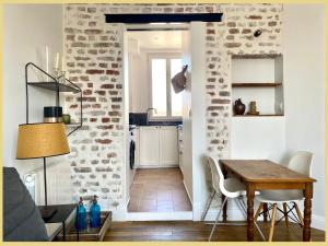 ein Wohnzimmer mit einem Tisch und einer Küche in der Unterkunft 07 La Puce de St Ouen by Fany S in Saint-Ouen