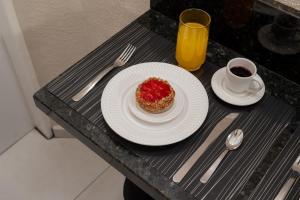 a table with a plate of food and a cup of coffee at Loft Coração da Serra in Serra Negra