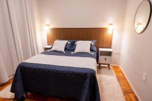 a bedroom with a large bed and a mirror at Loft Coração da Serra in Serra Negra