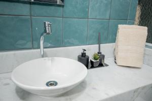 a white sink sitting on a counter in a bathroom at Loft Coração da Serra in Serra Negra