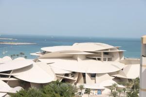 una representación arquitectónica de un edificio con sombrillas blancas en فندق شراعوه الملكي - Luxury, en Doha
