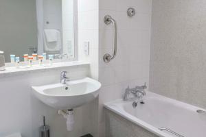 a white bathroom with a sink and a bath tub at Best Western Pontypool Metro Hotel in Pontypool