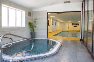 a swimming pool with a hot tub in a building at Best Western Plus Ullesthorpe Court Hotel & Golf Club in Lutterworth