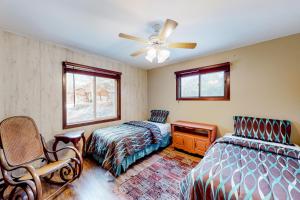 a bedroom with two beds and a ceiling fan at Roger's Place in Rhinelander