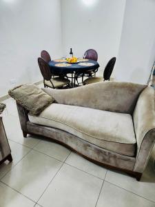 Private Rooms In Osu في آكرا: كنب جالس في غرفة مع طاولة