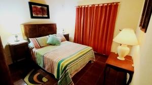 een slaapkamer met een bed en een tafel met een lamp bij Sueño Iberá in Colonia Carlos Pellegrini