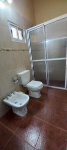 La salle de bains est pourvue de toilettes, d'un lavabo et d'une douche. dans l'établissement Sueño Iberá, à Colonia Carlos Pellegrini
