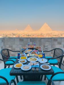 un tableau rempli de nourriture avec des pyramides en arrière-plan dans l'établissement Jumeirah pyramids view inn, au Caire