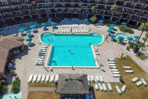 Una vista aérea de una piscina con sillas y sombrillas. en Hawaiian Inn 431, en Daytona Beach Shores