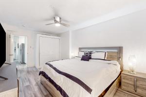 Un dormitorio con una cama grande y un ventilador de techo. en Hawaiian Inn 431, en Daytona Beach Shores 31 fotos más