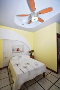 a bedroom with a ceiling fan and a bed at Hotel La Riviera in Sabalito