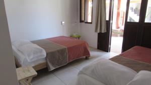 1 dormitorio con 2 camas y puerta a un balcón en Hab #3 La Casa Del Profe Salo, en Zapote