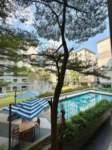 two umbrellas and chairs next to a swimming pool at 4mins walk to BTS! in Bangkok