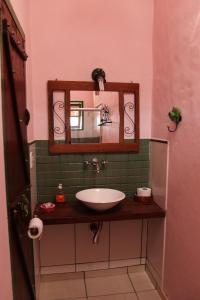 a bathroom with a sink and a mirror at Pousada Estalagem Mirante in Aiuruoca