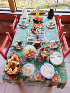 a table filled with food and plates of food at Pousada Estalagem Mirante in Aiuruoca