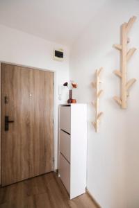 Cette chambre dispose d'un réfrigérateur et d'une porte en bois. dans l'établissement Bonnie&Beauty apartment, à Banská Bystrica
