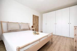 a white bedroom with a large bed and white cabinets at Bonnie&Beauty apartment in Banská Bystrica