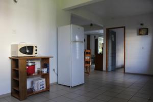 uma cozinha com um frigorífico branco e um micro-ondas em Villa Le Gommier, Meublé de tourisme 3 étoiles em Le Moule