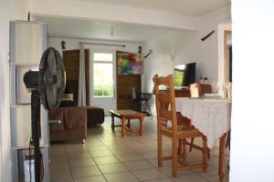 cocina y sala de estar con mesa y sillas en Villa Le Gommier, Meublé de tourisme 3 étoiles, en Le Moule