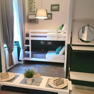 ナポリにあるGiordano's homeの小さな客室で、二段ベッド2台、テーブルが備わります。
