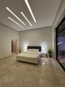 1 dormitorio grande con 1 cama y ventana grande en لاڤانا en Unayzah