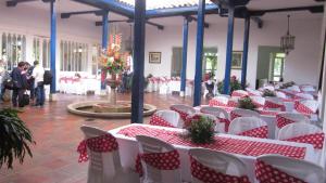 un salón de banquetes con mesas y sillas rojas y blancas en CLUB CAMPESTRE EL BOSQUE, en Silvania
