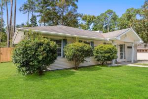 una casa bianca con due alberi in un cortile di Cottage in Diamondhead a Diamondhead