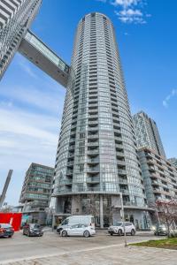 a tall building with cars parked in a parking lot at Cityplace Luxury suites in Toronto