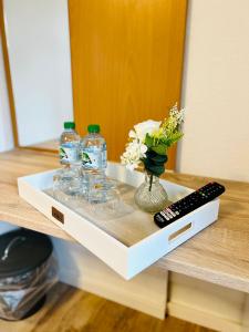 a shelf with glasses and bottles and a remote control at Pension Maria in Rochlitz