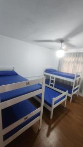 two bunk beds in a room with a ceiling at Hostel Lumaria 2 in Blumenau