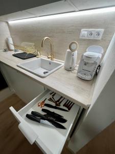 a kitchen counter with a sink and appliances on it at Bonnie&Beauty apartment in Banská Bystrica