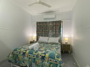 sypialnia z łóżkiem z kolorową kołdrą w obiekcie Whitehaven 2 w mieście Picnic Bay