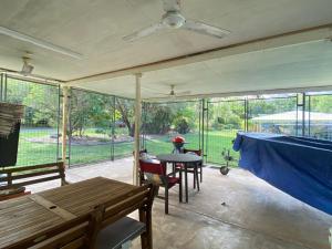 a screened in porch with a table and chairs at Whitehaven 2 in Picnic Bay
