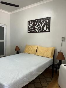 um quarto com uma cama e duas lâmpadas na parede em 4 Rooms + Pool in private historic Villa em Mombasa